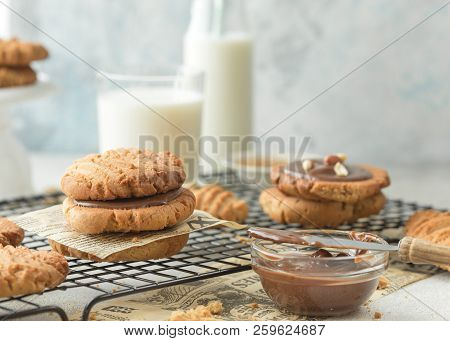 Peanut Butter Cookies On A Wooden Plate With Cookies On A Cooling Rack And Glass Of Milk. Peanut But