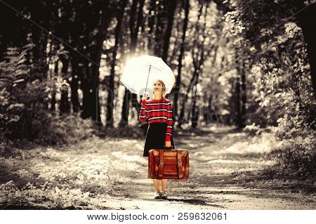 Young Girl With Umbrella And Suitcase In Park In Autumn Season