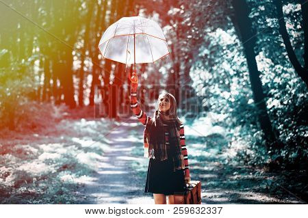 Young Girl With Umbrella And Suitcase In Park In Autumn Season