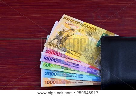 Ugandan Shilling In The Black Wallet On A Wooden Background