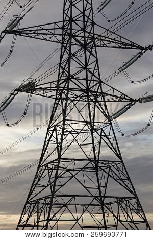 Electricity Pylons Or Transmission Towers Carrying High Voltage Power Lines And Overhead Cables Abov