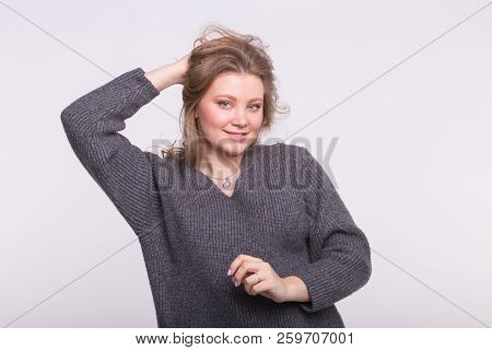 Plus-size Female Model With Hand In Hair Wearing Gray Sweater On White Background