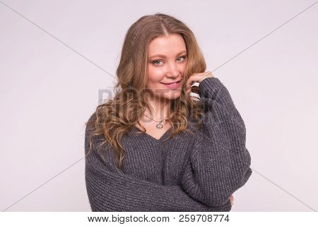 Close Up Portrait Of Caucasian Tender Woman With Curly Hair Wearing Gray Cardigan On White Backgroun