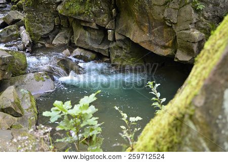 Small Waterfall On A Mountain River With Blue Water