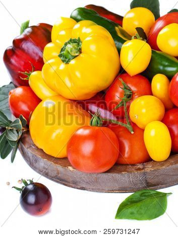 Assorted tomatoes and vegetables isolated on white background. Photo for your design.