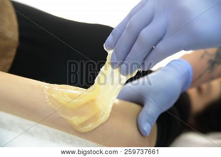 Beautician Removes Hair From A Woman's Hand.
