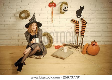 Halloween Coffee Or Tea Break. Woman In Witch Hat With Cups. Girl Sitting On Wooden Floor. Holiday C