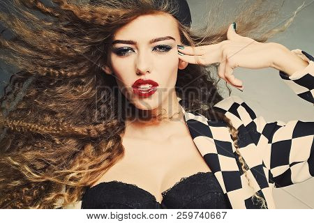 Portrait Of Attractive Woman With Fly-away Wavy Long Hair Wearing Black And White Cardigan Cap Under