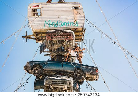 Guatemala - July 30, 2018. People Climbing Up The Huge Art Car Installation In The Middle Of A Deser