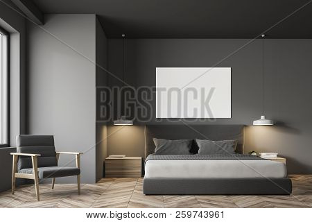 Gray Wall Minimalistic Bedroom Interior With A Wooden Floor, Masterbed, Night Stands And Gray Armcha