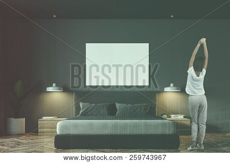 Woman In Pajamas Ing Gray Wall Minimalistic Bedroom Interior With A Wooden Floor, Masterbed On It An