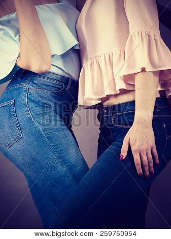 Two Unrecognizable Women Having Fashionable Outfits, Blue Jeans And Colorful Shirts. Fashion And Clo