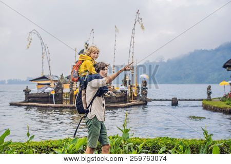 Dad And Son In The Background Of Pura Ulun Danu Bratan, Bali. Hindu Temple Surrounded By Flowers On 