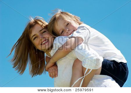 A mãe com filho pequeno contra o céu
