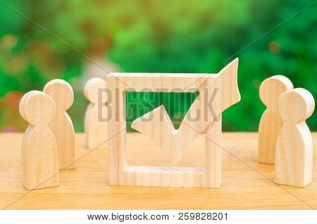 Human Figures Stand Together Next To A Tick In The Box. The Concept Of Elections And Social Technolo