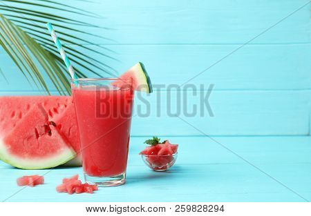 Summer Watermelon Drink In Glass And Sliced Fruit On Table Against Color Background With Space For T