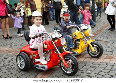 MUKACZEWO, Ukraina - 1 maja: Niezidentyfikowane dzieci trzy rok stary poza na mini motorcyc trzy koło