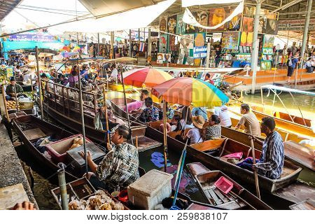 BANGKOK – MARCH 18: People shopping food from wooden boats at Amphawa floating market on March 18, 2