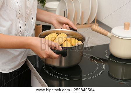 Woman Preparing Corn In Stewpot On Stove, Closeup