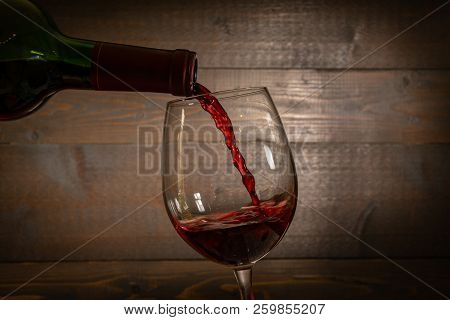 Red Wine Pouring Into A  Wineglass From A Bottel