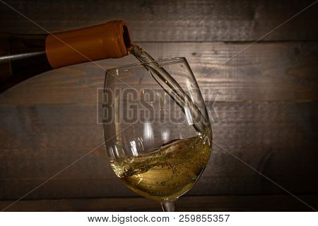 White Wine Pouring Into A  Wineglass From A Bottel