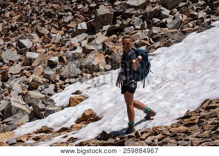 Female Backpacker Hiker Holds A Snowball On The Trail Of Talus And Scree In The Eastern Sierra Nevad