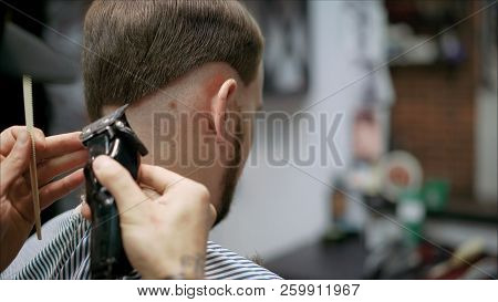 Men's Haircut In Barbershop. Master Barber Does A Haircut To The Client. Work With Scissors And Clip