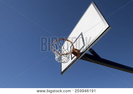 Basketball Hoop and backboard set against Blue Sky
