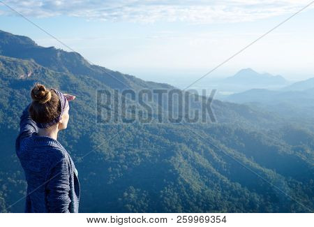 A Woman Looking Afar Atop A Mountain