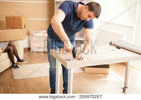 Man Assembling Furniture In Their New Flat