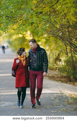 Young Loving Couple, Smiling Woman And Happy Man In Casual Warm Clothes Walking, Embracing And Looki