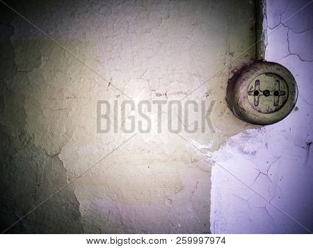 Old Electrical Outlet And Cable On A Decrepit Wall. Rusted Surface. Copy Space For Your Text. Old Br