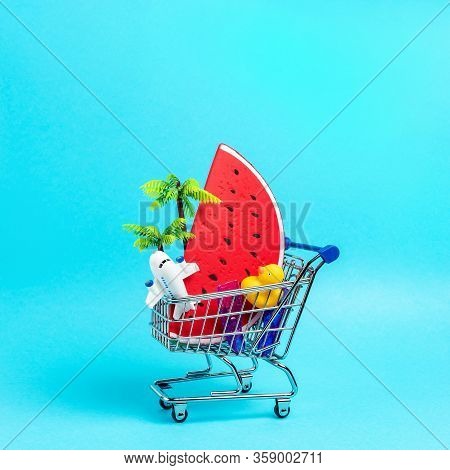 Tropical Beach Concept Made With Summer Things In Shopping Troley On Blue Background. Creative Minim
