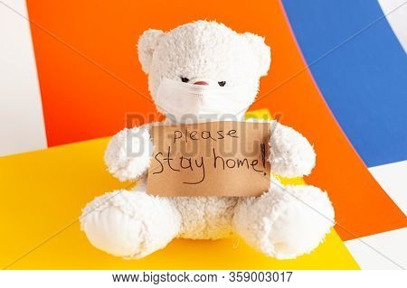 A Teddy Bear In A Medical Mask Holds In His Paws A Sign That Says Please Stay Home