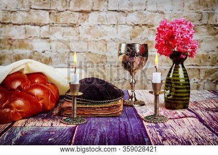 Shabbat Candles In Candlesticks Of Loaves Challah For Shabbat Wine In A Cup With Flowers