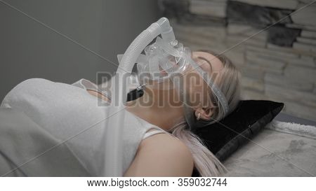 Girl Lies On Bed With Artificial Respiration Mask