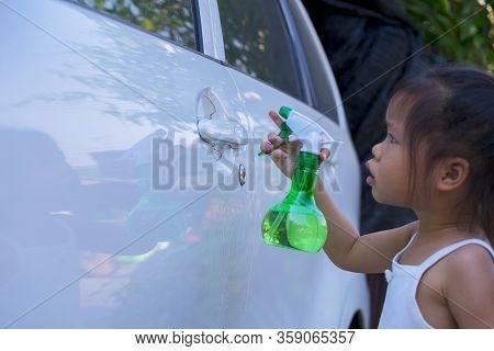 Asian Children Spry Soap To Clean Car Door Handle.