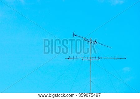 Rusted Old Steel Antenna Tower Isolated On Clear Blue Sky Background With Motion Blurred Bird Holdin