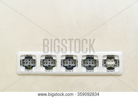 White Socket Outlets On Beige Wall Witout Cover. Copy Space. Eu Standart Electric Outlets.