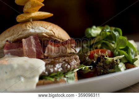 Burger Of Beef Meat With Melted Chedar Cheese, Bacon,tomato, Rocket Salad With Spicy Fries On The Ta