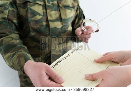 Police Officer With Handcuffs In Khaki Colored Uniform Stops People On The Street For Violating Rule