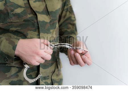 Police Officer With Handcuffs In Khaki Colored Uniform Stops And Arrest Criminal On The Street For V