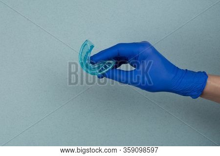 Myofunctional Trainer For Correction Of Bite And Alignment Of Teeth In The Hand Of Doctor In The Glo