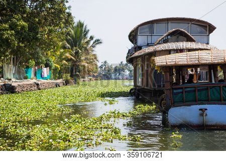 Alapuzha, Kerala, India-february 4, 2019. A Pleasure Boat And House-boat On The Seaweed-covered Rive