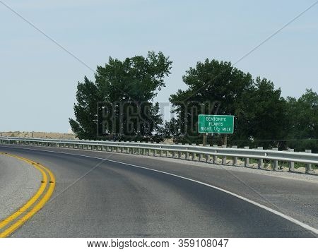Roadside Sign Along A Winding Road With Distance To  Bentonite Plants In Wyoming.