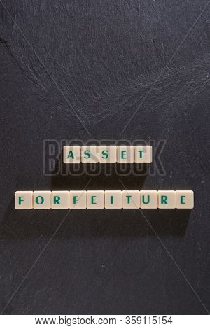 Asset forfeiture word made of square letter word on textured black background.
