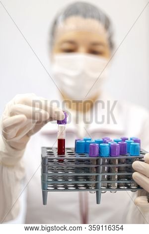 Scientist, Nurse Or Doctor With Mask And Gloves Holding A Rake Of Tubes With Medical Analysis, Blod,