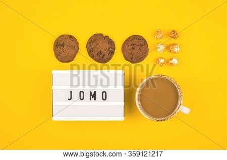 Abbreviation Word Jomo Written On A Decorative Board On A Bright Yellow Background. The Concept Of R