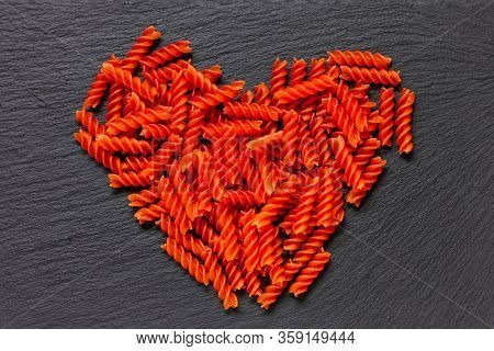 Heart-shaped Organic Red Lentil Pasta On Rustic Black Backgrond. I Love To Be Vegan. Gluten Free. To