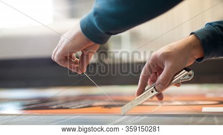 Close-up Of Hand With Skalpel. Worker Cut Paper In Printshop